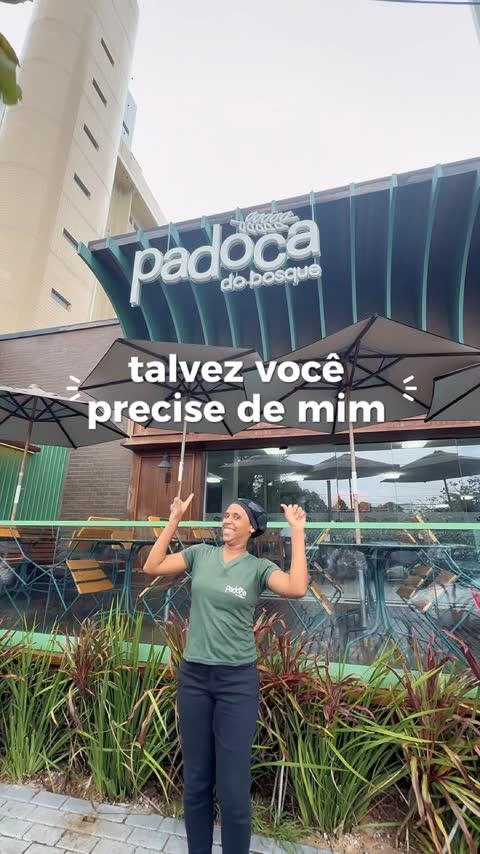 Fachada de esquina da Padoca do Bosque, com marquise verde e mesas na calçada