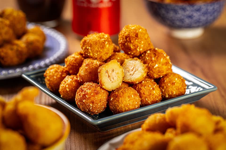 Bolinhos fritos dourados empilhados num prato azul